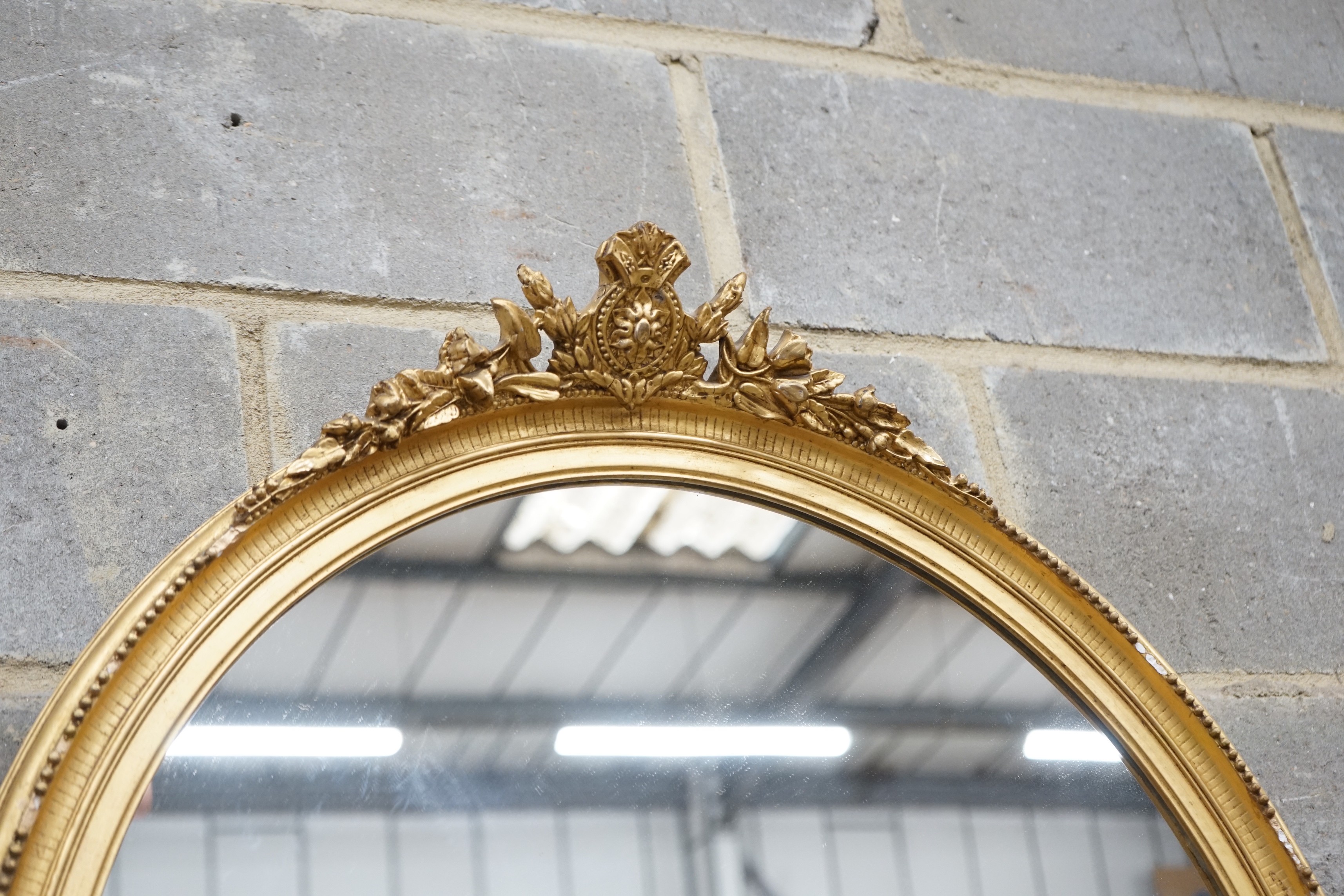 An early 20th century gilt wood and gesso oval wall mirror width 75cm height 96cm.